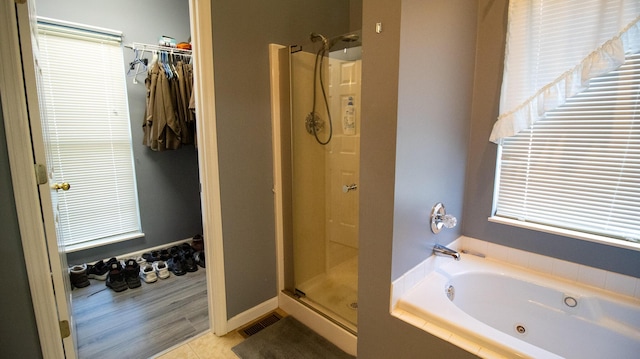 bathroom featuring tile patterned flooring, plenty of natural light, and shower with separate bathtub