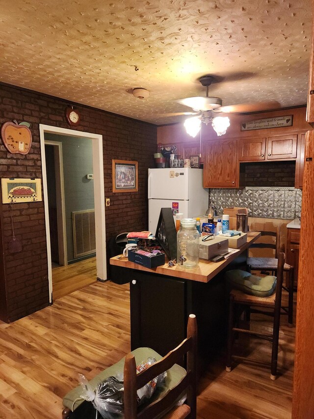 204 Clearview Dr, Bean Station, TN 37708 - home office featuring brick wall, ceiling fan, light wood-style floors, and a textured ceiling