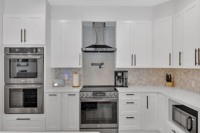 1936 Turners Landing Rd, Russellville, TN 37860 - kitchen featuring white cabinets, wall chimney range hood, stainless steel appliances, and tasteful backsplash