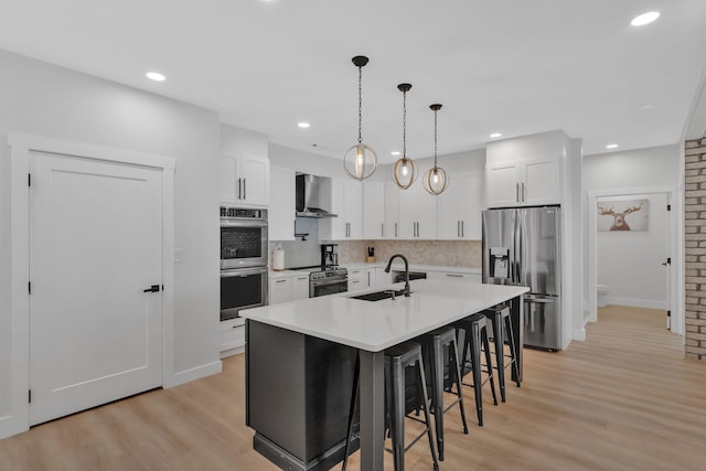 1936 Turners Landing Rd, Russellville, TN 37860 - kitchen featuring white cabinets, wall chimney range hood, sink, an island with sink, and stainless steel appliances