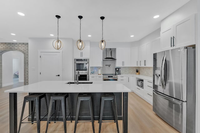 1936 Turners Landing Rd, Russellville, TN 37860 - kitchen featuring decorative backsplash, wall chimney exhaust hood, stainless steel appliances, white cabinets, and an island with sink