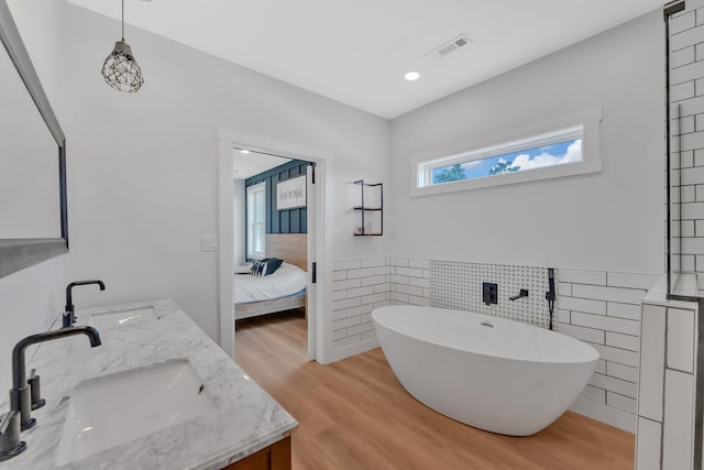 1936 Turners Landing Rd, Russellville, TN 37860 - bathroom featuring a tub to relax in, hardwood / wood-style floors, vanity, and tile walls