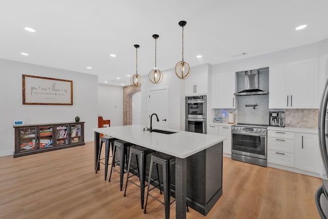 1936 Turners Landing Rd, Russellville, TN 37860 - kitchen with a kitchen island with sink, white cabinets, wall chimney range hood, sink, and appliances with stainless steel finishes