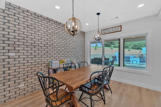 1936 Turners Landing Rd, Russellville, TN 37860 - dining area featuring light hardwood / wood-style flooring, brick wall, and an inviting chandelier