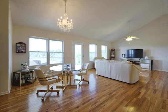 dining room with lofted ceiling, wood-type flooring, and ceiling fan with notable chandelier
