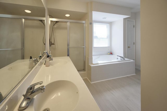 bathroom featuring vanity, wood-type flooring, and shower with separate bathtub