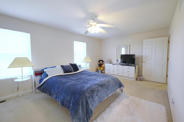 carpeted bedroom with multiple windows and ceiling fan