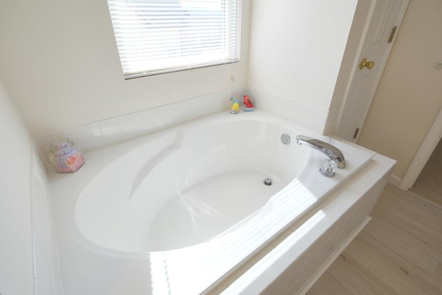 bathroom featuring hardwood / wood-style flooring and a bath