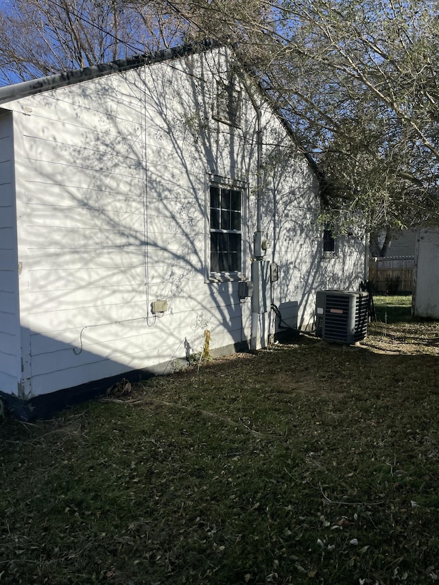 view of property exterior featuring a lawn and central AC