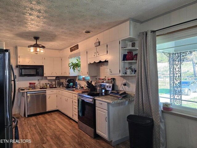 kitchen with white cabinetry, black appliances, a textured ceiling, and a sink
