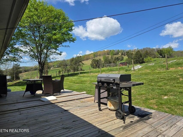 deck featuring a lawn, grilling area, and outdoor dining area