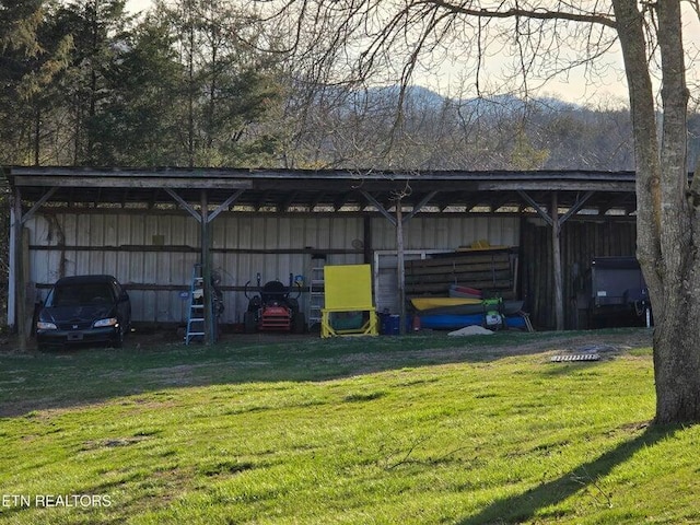 view of pole building with a carport and a yard