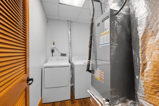 washroom with wood-type flooring, washing machine and dryer, and heating unit