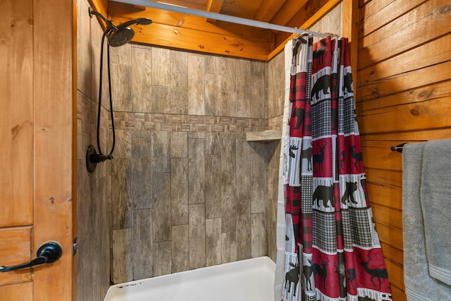 bathroom with a shower with shower curtain and wooden walls