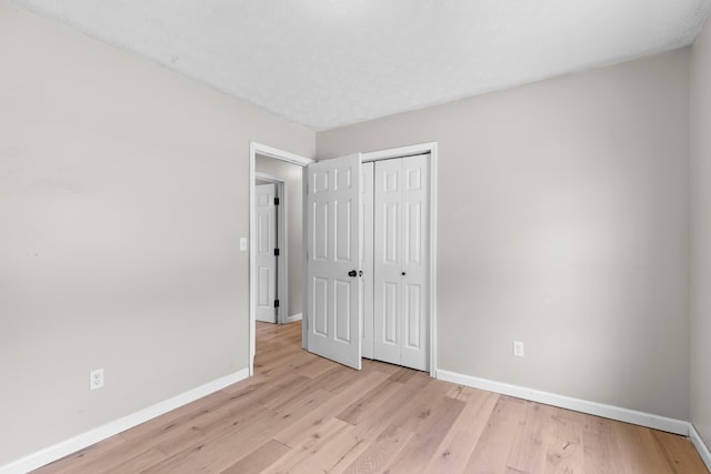 unfurnished bedroom featuring light wood-type flooring and a closet