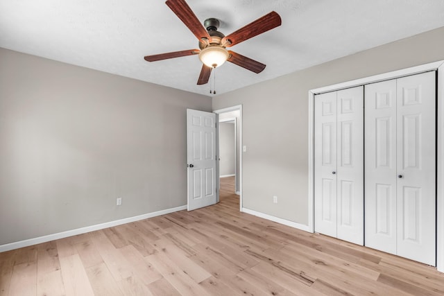 unfurnished bedroom with light wood-type flooring, a closet, and ceiling fan