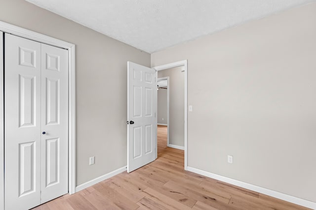 unfurnished bedroom featuring light hardwood / wood-style floors and a closet