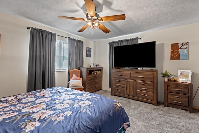 bedroom with light carpet, a ceiling fan, and a textured ceiling