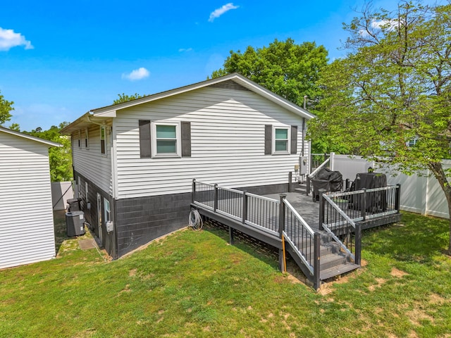 rear view of house with fence, a wooden deck, a yard, and central AC unit