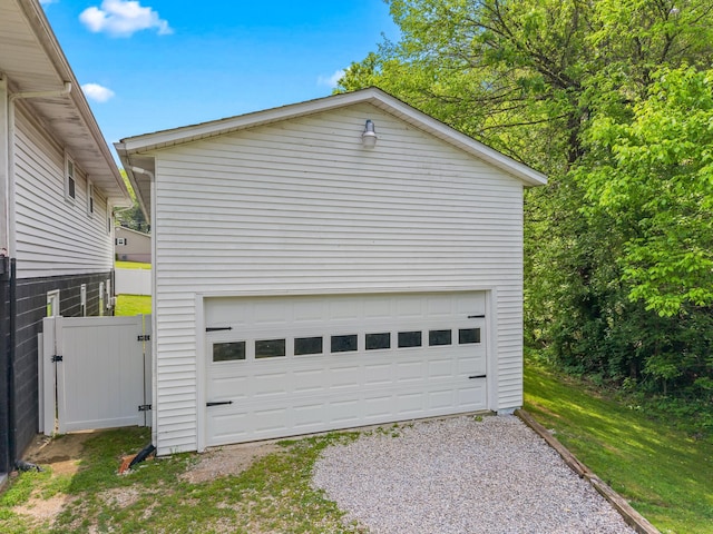 detached garage with a gate and fence