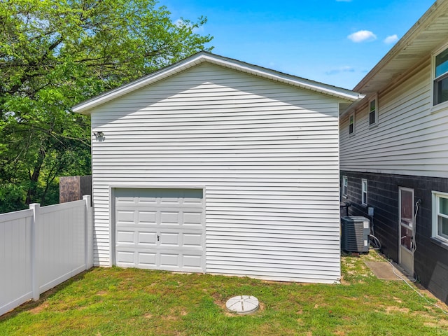 view of property exterior with central air condition unit, fence, and a yard