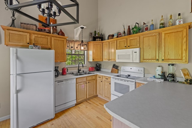 5014 Latta Way, Gatlinburg, TN 37738 - kitchen featuring light wood-style flooring, white appliances, hanging light fixtures, a sink, and light countertops