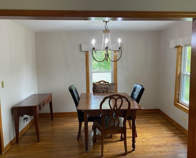 dining space featuring a healthy amount of sunlight, light wood-type flooring, and an inviting chandelier