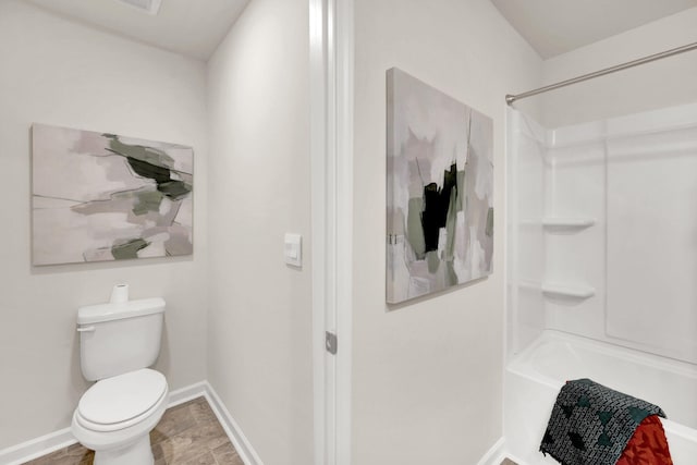 full bathroom featuring toilet, baseboards, and shower / washtub combination