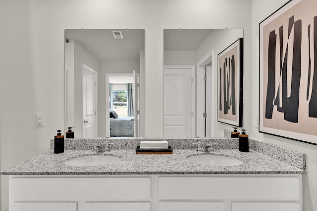 bathroom featuring double vanity, visible vents, and a sink