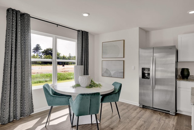 dining space with light wood-type flooring, baseboards, and recessed lighting