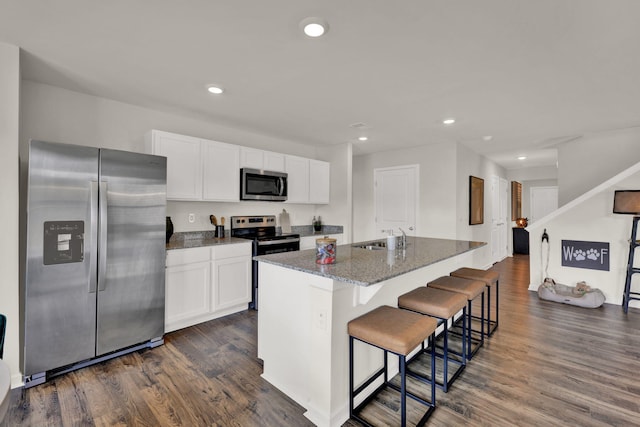 kitchen featuring stainless steel appliances, dark wood-style flooring, white cabinets, and a sink