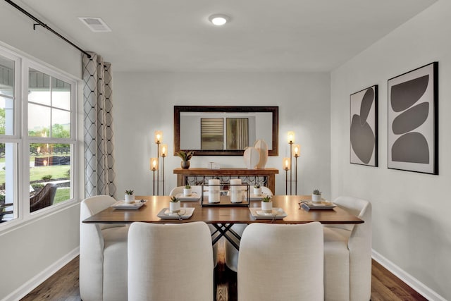 dining area featuring wood finished floors, visible vents, and baseboards