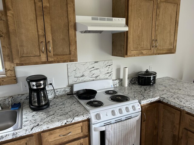 1101 Beason Ridge Rd, New Tazewell, TN 37825 - kitchen with white electric stove, under cabinet range hood, and brown cabinetry