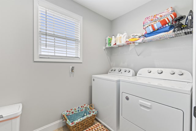 washroom with washing machine and clothes dryer, baseboards, and laundry area
