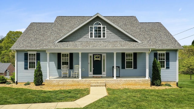 view of front facade featuring roof with shingles, a front lawn, and covered porch