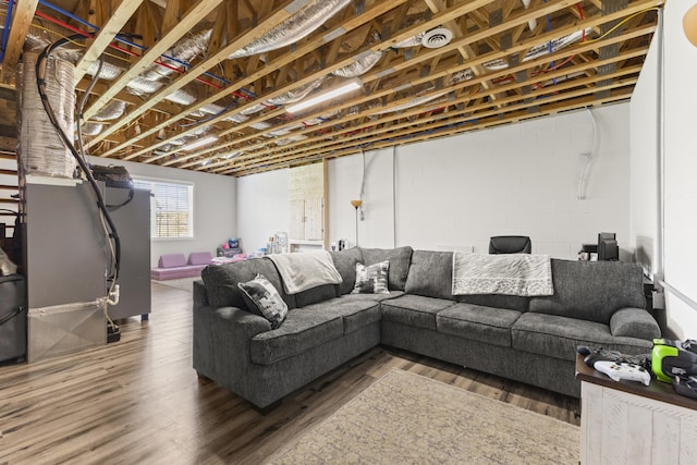 living area with concrete block wall and wood finished floors