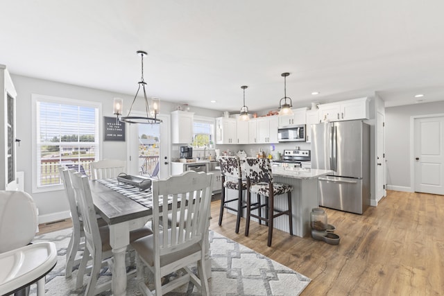 dining area with baseboards, light wood-style floors, and recessed lighting