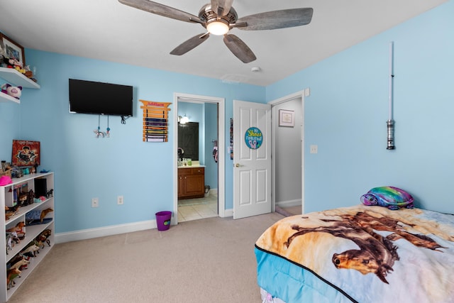 bedroom with connected bathroom, light colored carpet, and ceiling fan