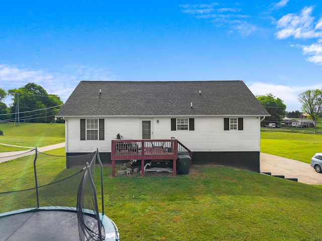 back of property with a shingled roof, a yard, and a deck