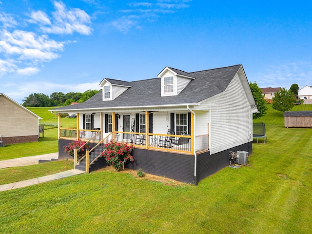 view of front of property with a porch, a trampoline, central air condition unit, and a front lawn