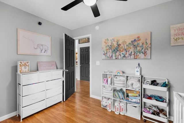 interior space with baseboards, ceiling fan, and light wood-type flooring