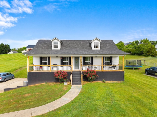 view of front of house featuring a trampoline, covered porch, and a front yard