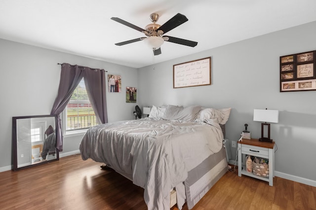 bedroom featuring baseboards, ceiling fan, and wood finished floors
