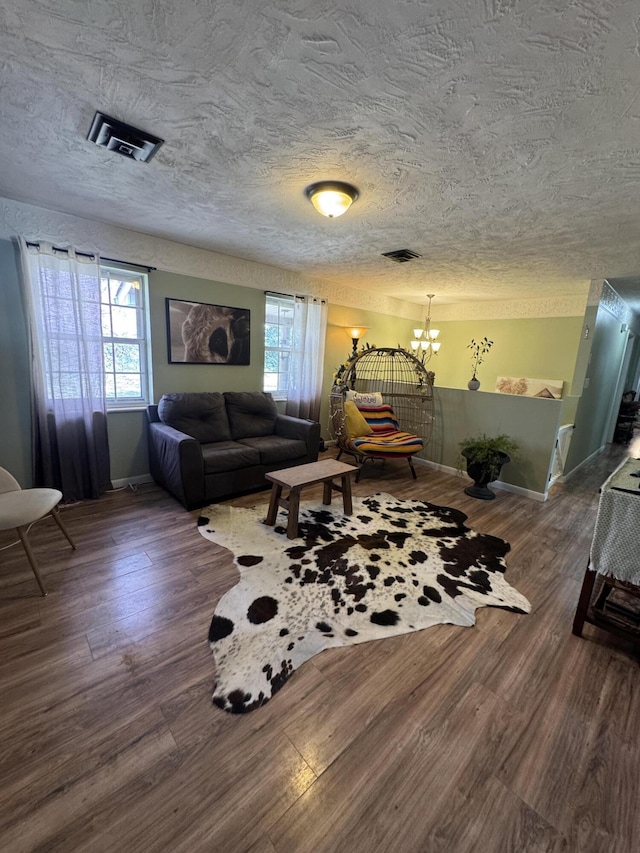 living area with a wealth of natural light, visible vents, and wood finished floors