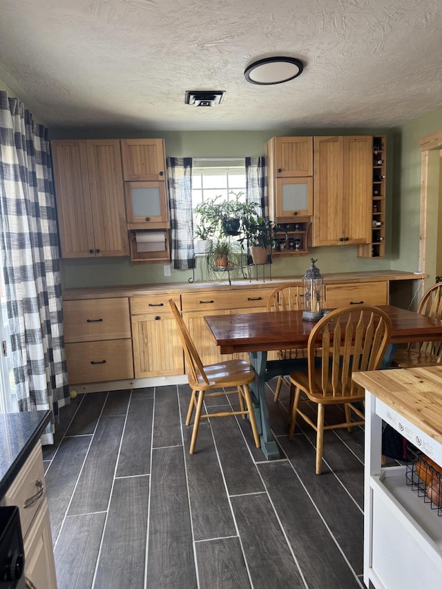 kitchen with visible vents, a textured ceiling, and wood finish floors