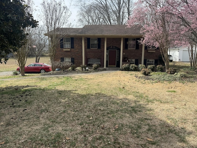 bi-level home featuring brick siding and a front yard