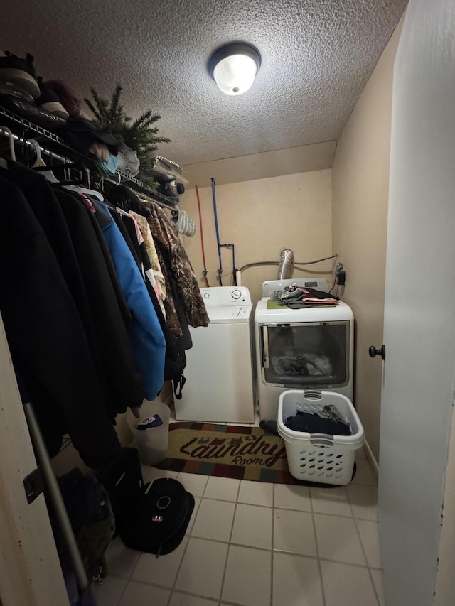 laundry room with laundry area, independent washer and dryer, and a textured ceiling