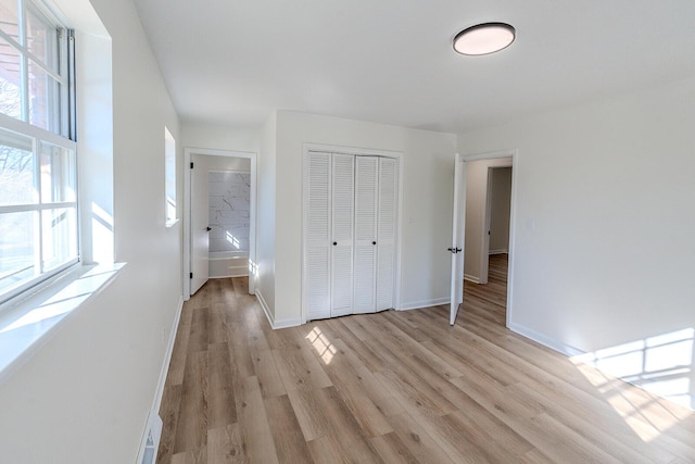 unfurnished bedroom with light wood-type flooring and a closet