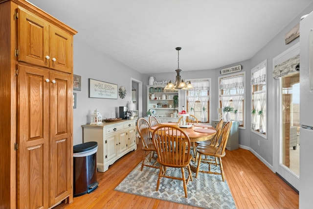 dining area with a chandelier and light wood-type flooring