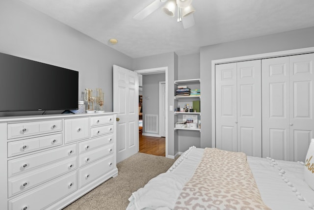 bedroom featuring ceiling fan, a closet, and light carpet